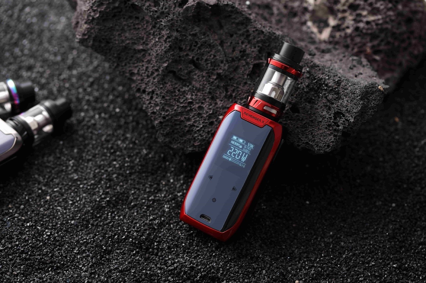 A Vaporesso vape kit sitting on a black sand beach.